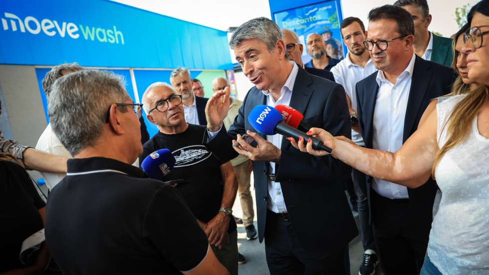 O secretário-geral do Partido Socialista (PS), José Luís Carneiro (C), conversa com um popular  depois de abastecer a viatura oficial do partido num posto de abastecimento como alerta para o aumento do preço dos combustíveis, em Paredes, 27 de julho de 2026. JOSÉ COELHO/LUSA