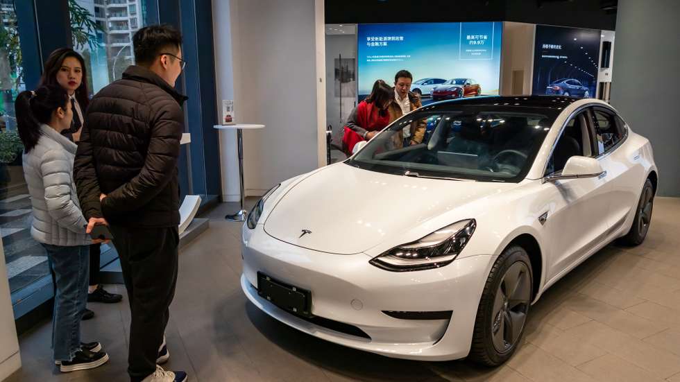 epa08110483 Customers look at Tesla's China-made Model 3 at Tesla's Experience Center, in Shanghai, China, 07 January 2020. Ten customers became the first owners of the electric cars beyond the Tesla staff.  EPA/WANG GANG CHINA OUT