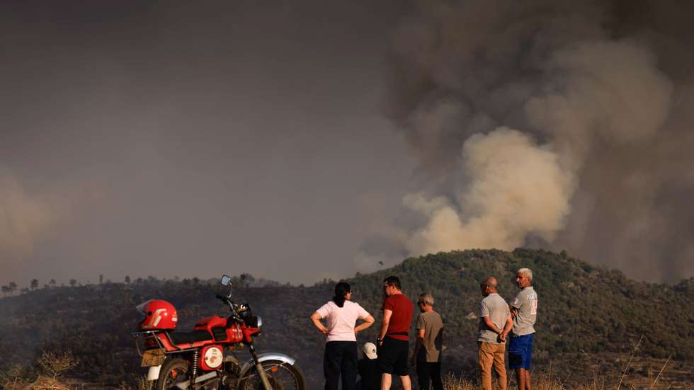 Local people watch the flames and smoke of a forest fire, which started in Torre de Moncorvo and spread to the municipality of Carrazeda de Ansiães, in Vilarinho da Castanheira, Portugal, 17 August 2026. PEDRO SARMENTO COSTA/LUSA