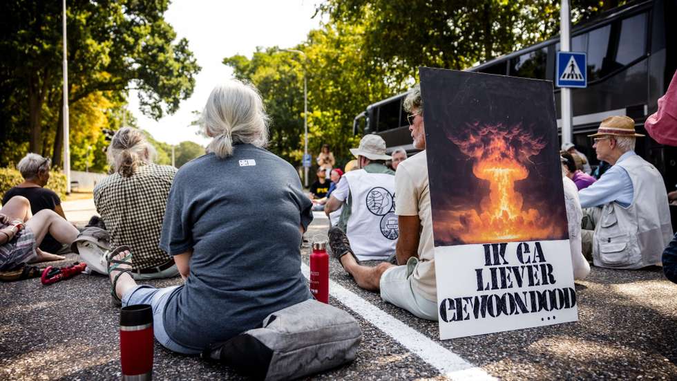 epa13148325 Demonstrators take part in a silent si-in blockade at the main gate of Volkel military air base in Volkel, Netherlands, 03 August 2026. The demonstrators block the entrance to commemorate the atomic bombs dropped on Hiroshima and Nagasaki 81 years ago and to and to protest against the presence of nuclear weapons at the base.  EPA/ROB ENGELAAR