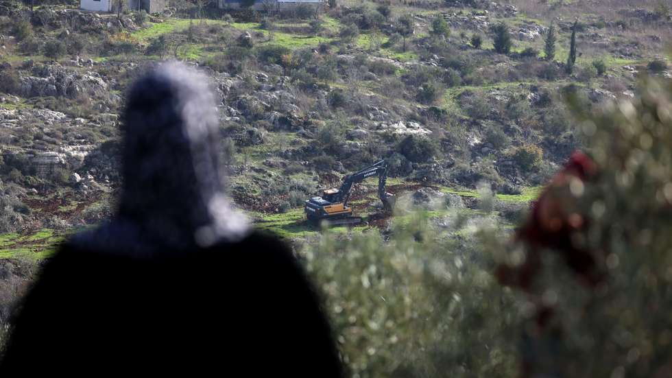 epa12608765 Palestinians watch as Israeli bulldozers level agricultural lands in the town of Silat al-Harithiya, near the West Bank city of Jenin, 22 December 2025. According to the Palestinian news agency Wafa, Mayor Samir Zayoud stated that the machinery began leveling farmlands early in the morning in the al-Suruj area, situated between Silat al-Harithiya and Ya'bad.  EPA/ALAA BADARNEH