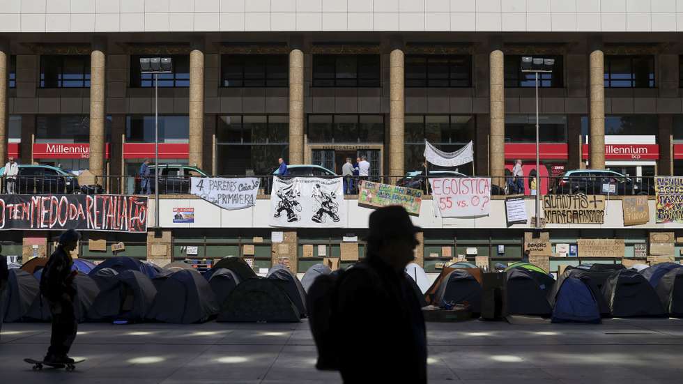Manifestantes pelo direito à habitação permanecem na Praça D. João I no Porto, 19 de outubro de 2026. O movimento pela habitação, que há uma semana ocupa a Praça D. João I, no Porto, prolongou no domingo à noite o pré-aviso de manifestação até dia 31 de dezembro. ESTELA SILVA/LUSA