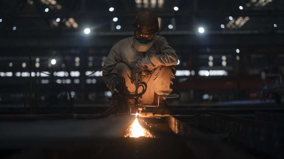 epaselect epa09467467 A man works in Nantong COSCO KHI Ship Engineering factory in Nantong Jiangsu province, China, 14 September 2021. Nantong COSCO KHI Ship Engineering Co., Ltd, NACKS, is the Sino-foreign joint venture shipbuilding company between China Ocean Shipping Company (COSCO) and Kawasaki Heavy Industries Ltd. (KHI). The shipbuilding company develops, design, researches and manufactures container ships, crude carriers, bulk carriers and other vessels.  EPA/ALEX PLAVEVSKI