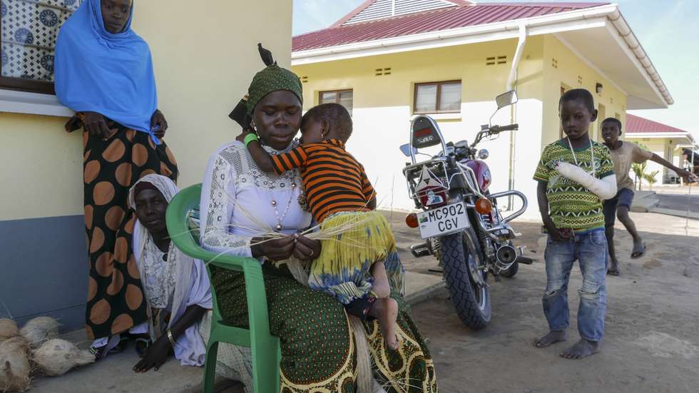 Populares junto às suas novas casas na nova vila de Quitunda, criada para alojar os habitantes desalojados por causa megaprojeto de gás na península de Afungi, Cabo Delgado, Moçambique, 19 de junho de 2020. No lugar de uma povoação rural de construções precárias, agora há uma vila com infraestruturas (água, eletricidade, saneamento, acesso) como não existe em mais lado nenhum da província. Na nova Quitunda já habitam 186 famílias (cerca de 1.200 pessoas), transferidas de povoados dos terrenos de implantação do projeto e novas fases de expansão estão previstas para o total a acolher chegar a 556 famílias. (ACOMPANHA TEXTO DA LUSA DO DIA 27 DE JUNHO DE 2020). LUÍS MIGUEL FONSECA/LUSA