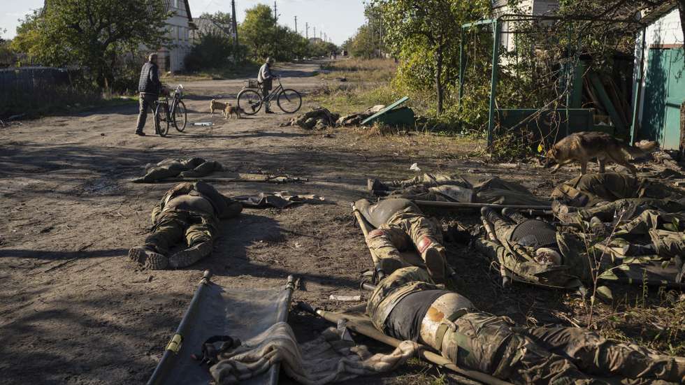 epa10228291 Local residents pass by the dead bodies of Russian soldiers that remain on a street in the recently recaptured city of Lyman in the Luhansk area, Ukraine, 06 October 2022 amid Russia's military invasion. According to locals who witnessed the recapturing of the area by Ukrainian troops, the bodies were being prepared for evacuation but were left when Russian troops were pushed out of Lyman. The Ukrainian army pushed Russian troops from occupied territory in the northeast of the country in a counterattack. Russian troops entered Ukraine on 24 February 2022 starting a conflict that has provoked destruction and a humanitarian crisis.  EPA/ANASTASIA VLASOVA ATTENTION: GRAPHIC CONTENT