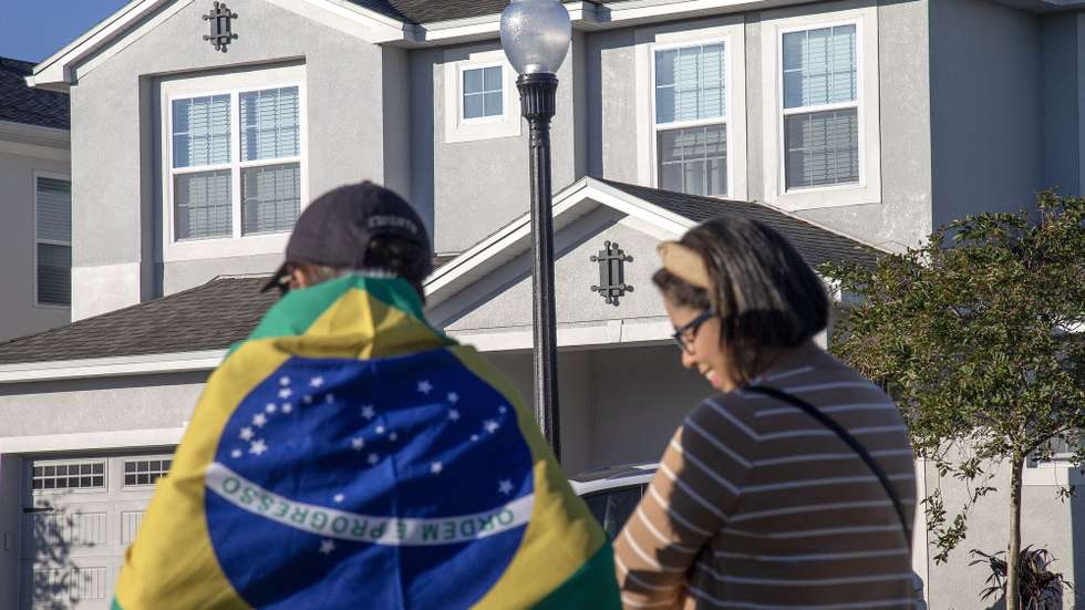 epa10401534 People stand in front of the house at the Encore Resort Homes, where former Brazil president Jair Bolsonaro is staying, in Reunion, Florida, USA, 12 January 2023. US Lawmakers called US President Joe Biden to extradite Bolsonaro back to his country from Florida. Bolsonaro has been staying in Central Florida, near Orlando, as his supporters protest in Brazil.  EPA/CRISTOBAL HERRERA-ULASHKEVICH