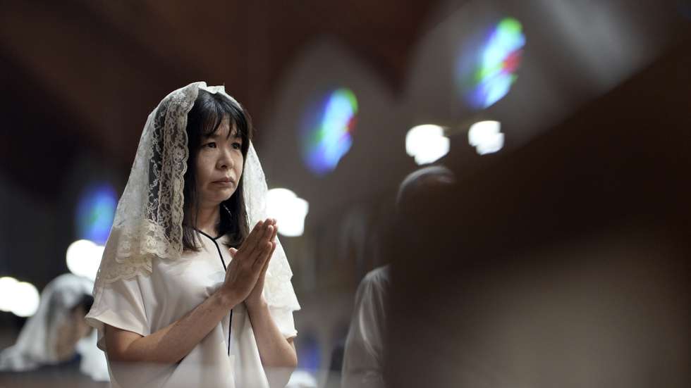 epaselect epa12290582 A churchgoer prays during an early morning mass at Urakami Cathedral in Nagasaki, Japan, 09 August 2025, the day of the 80th anniversary of the atomic bombing. In 1945, the United States dropped two nuclear bombs over the cities of Hiroshima and Nagasaki on 06 and 09 August, respectively, killing more than 200,000 people.  EPA/FRANCK ROBICHON