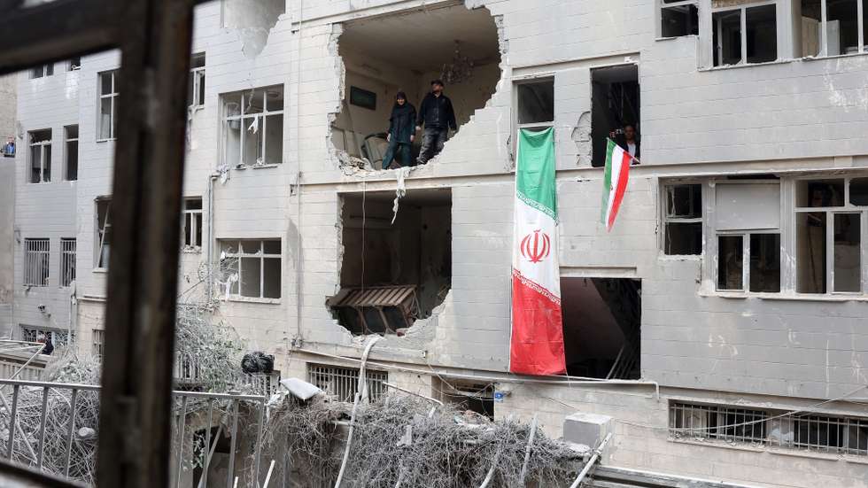 epa12821312 Iranians stand inside their damaged residential building in southern Tehran, Iran, 15 March 2026. A joint Israeli and US military operation continues to target multiple locations across Iran since the early hours of 28 February 2026.  EPA/ABEDIN TAHERKENAREH