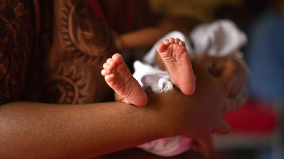 epa09276212 A woman holds her newborn child as she waits inside a room after receiving a dose of Covid-19 vaccine at Government Maternity Hospital, in Chennai, India, 16 June 2021. Lactating mothers now allowed to get COVID-19 vaccine in India.  EPA/IDREES MOHAMMED