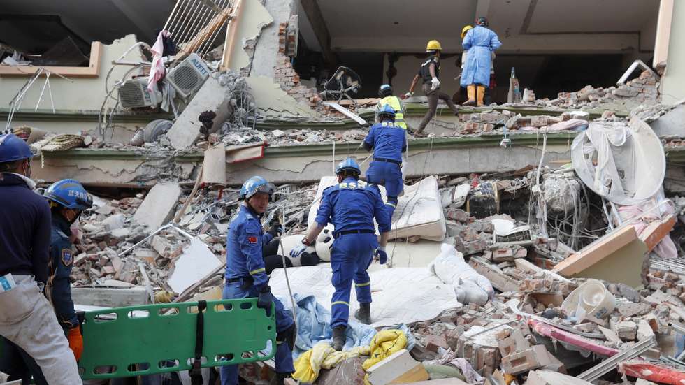 epa11999786 Chinese rescuers search for victims at the Sky Villa in Mandalay, Myanmar, 30 March 2025. More than 1,600 people have been killed and thousands injured after a 7.7-magnitude earthquake struck the country on 28 March, according to the Myanmar government.  EPA/NYEIN CHAN NAING
