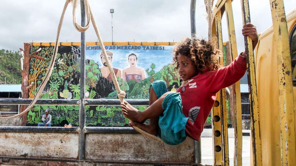 epaselect epa05726510 An East Timorese girl plays swing on a truck at Taibesi traditional market in Dili, East Timor, also known as Timor Leste, 18 January 2017.  EPA/ANTONIO DASIPARU