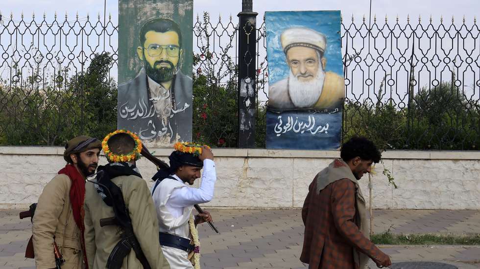 epa13221042 Armed people walk past paintings depicting late Houthi leaders on display on a fence in Sana'a, Yemen, 07 September 2026. United Nations Special Envoy for Yemen Hans Grundberg warned of grave consequences for civilians in Yemen due to the recent escalation of fighting between the Houthis and government forces, calling on the warring parties to prevent further escalation.  EPA/YAHYA ARHAB