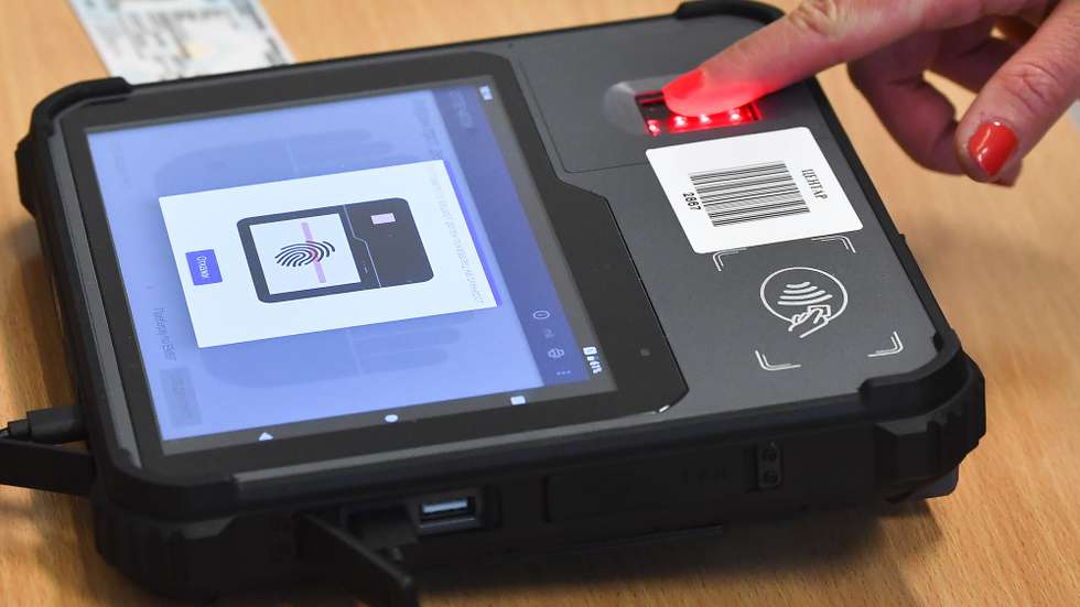 epa09528331 A woman put her finger on the devices for biometric identification of the fingerprint at the polling station in Skopje, Republic of North Macedonia, 17 October 2021. 1,824,864 citizens have the right to vote. For the first time in these elections, the identity of the voters will be checked with devices for biometric identification of the fingerprint. Before you can exercise your voting right, your fingerprint will first have to match that of the database inserted in the identification device.  EPA/GEORGI LICOVSKI