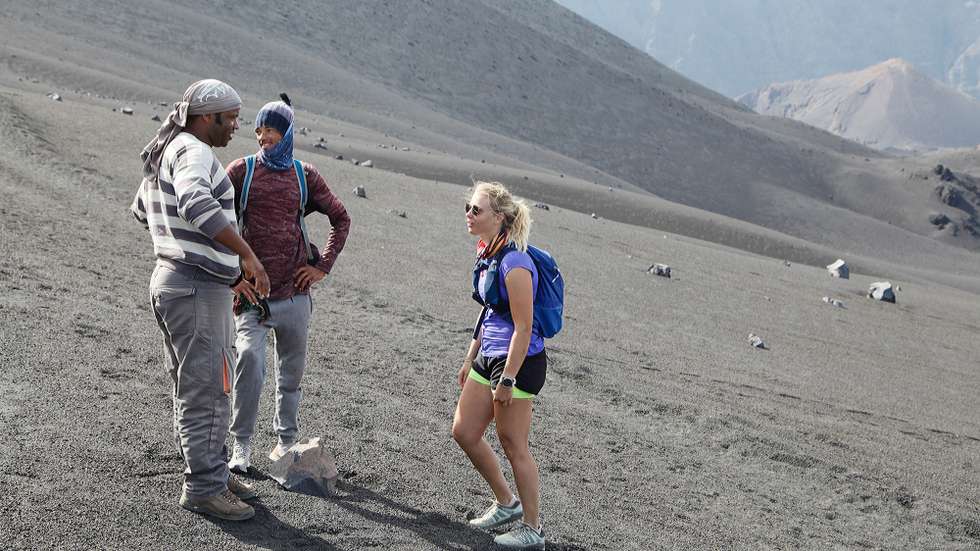 O presidente Associação de Guias de Turismo de Chã das Caldeiras, João Pedro de Pina Silva (E), conversa com turistas durante a subida ao pido do vulcão do Fogo, na Chã das Caldeiras, ilha do Fogo, Cabo Verde, 14 de novembro de 2019. Além dos picos, Grande e Pequeno, os 80 turistas que chegam a escalar o vulcão num dia, logo a partir das 05:00, procuram ainda o trilho da descida aos Mosteiros, mas a o vulcão tem ainda cerca de uma dezenas de outros percursos disponíveis. (ACOMPANHA TEXTO DO DIA 30 DE NOVEMBRO DE 2019). FERNANDO DE PINA/LUSA