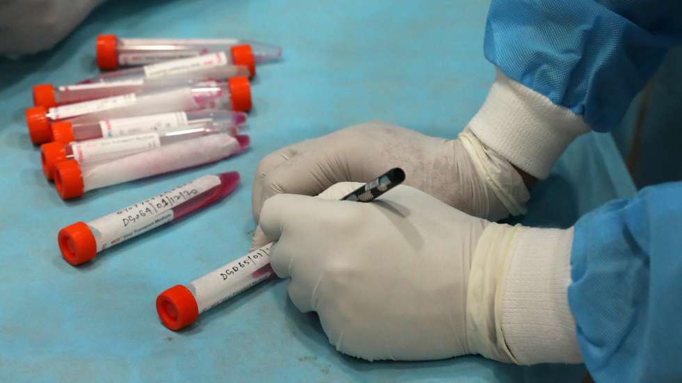 epa08854227 A health worker prepares vials to collect swab samples for a COVID-19 RT-PCR test in New Delhi, India, 01 December 2020. The Delhi government has cut the price of RT-PCR test by more than half amid a third wave of Covid-19 infections sweeping through the country.  EPA/RAJAT GUPTA