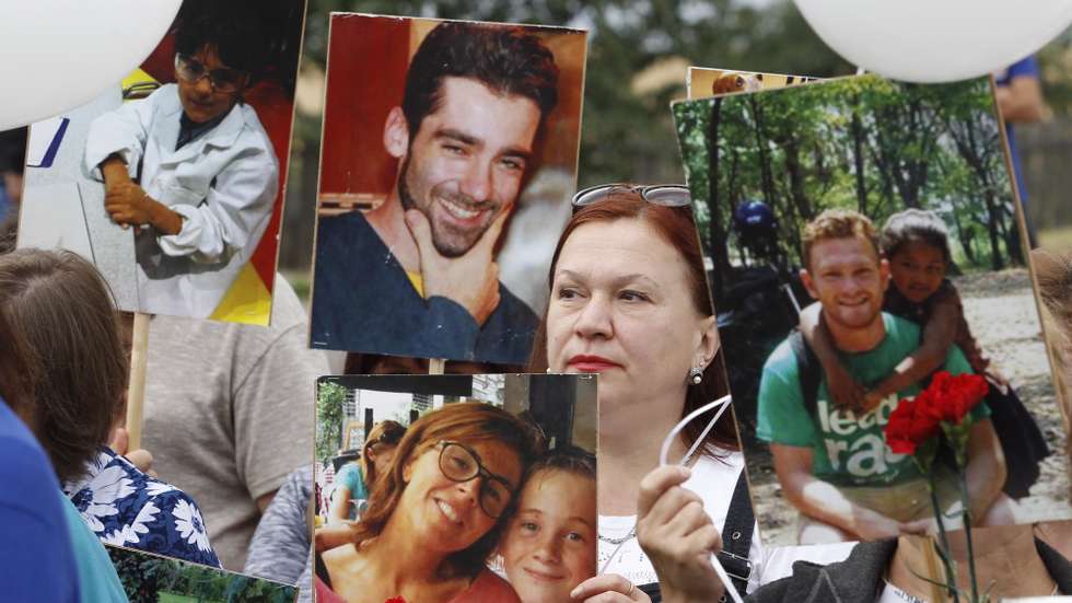 epa08552030 Local people hold portraits of lost passengers during a mourning ceremony at the crash site of the MH17 plane, on the sixth anniversary of the disaster, near the pro-Russian militant's controlled village of Grabovo, around 100 kilometers east from Donetsk, Ukraine, 17 July 2020. Malaysia Airlines Flight MH-17 was shot down on 17 July 2014 while flying over eastern Ukraine, killing all 283 passengers and 15 crew on board.  EPA/DAVE MUSTAINE