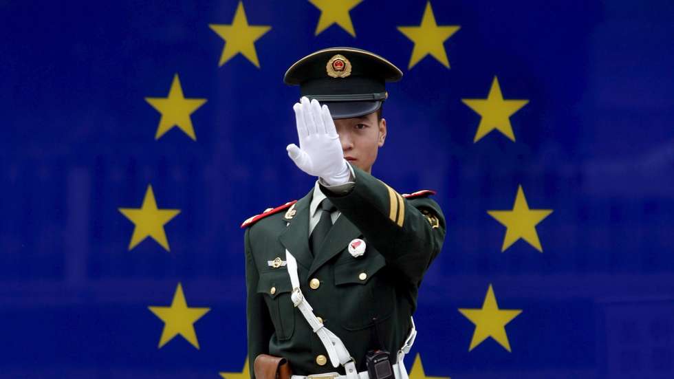 epa01162759 A Chinese paramilitary police officer reacts to having his photograph taken in front of the image of the European Union (EU) flag at the EU embassy in Beijing, China, 02 November 2007.  EU officials are proposing increased anti-dumping measures following continued accusations that China is engaging in unfair trade practices, causing friction in bilateral relations.  EU steel producers and textile manufacturers claim China hoards an enormous trade surplus while maintaining strict trade barriers. The EU is China's largest trading partner, ahead of the US and Japan, as Chinese exports to the EU increased nearly 21 percent year-on-year in 2006, according to the European Commission.  EPA/MICHAEL REYNOLDS