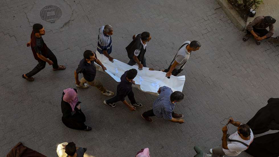 epa12462096 Palestinians carry the body of a member of the Abu Shaban family at Al Ahli Baptist Hospital in Gaza City, Palestine, 18 October 2025. At least eleven members of the Abu Shaban family were killed a day earlier when their car was hit by an Israeli army strike in the Al Zaitun neighbourhood, east of Gaza City.  EPA/MOHAMMED SABER