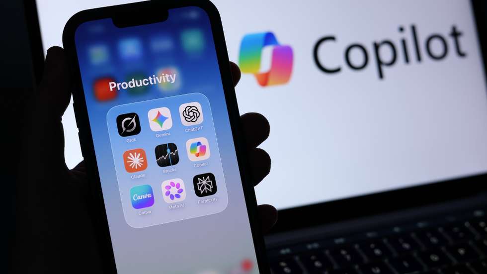 epa13026211 A 'Productivity' folder containing Artificial Intelligence applications is displayed on a mobile phone alongside the Microsoft Copilot logo displayed on a laptop screen in Liverpool, Britain, 09 June 2026. Leading AI (artificial intelligence) and technology companies Anthropic, OpenAI, and SpaceX are preparing to go public this year at an estimated combined valuation of around four trillion dollars (approximately 3.44 trillion euros).  EPA/ADAM VAUGHAN