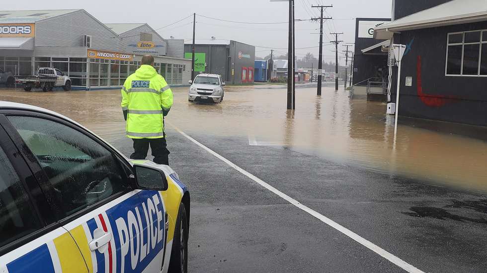 epa10465753 A handout photo made available by the New Zealand Police assisting motorists around flood waters in Whangārei, New Zealand, issued 13 February 2023. The New Zealand government is considering a national state of emergency, with tens of thousands of homes without power and Cyclone Gabrielle's worst still to come as the storm surges south.  EPA/NEW ZEALAND POLICE HANDOUT AUSTRALIA AND NEW ZEALAND OUT HANDOUT EDITORIAL USE ONLY/NO SALES/NO ARCHIVES