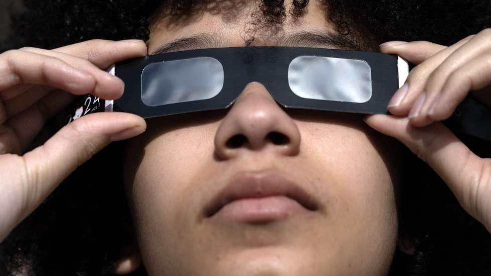 epa11996767 A person uses protective glasses to watch a partial solar eclipse, at Greenwich Observatory in London, Britain, 29 March 2025. A solar eclipse happens when the Moon passes between the Sun and Earth, casting a shadow on Earth that either fully or partially blocks the Sun’s light in some areas.  EPA/NEIL HALL
