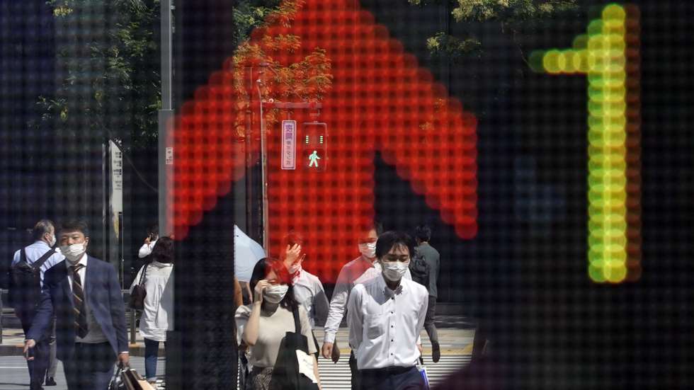 epa09485078 Passersby are reflected in a stock market indicator board in Tokyo, Japan, 24 September 2021. The 225-issue Nikkei Stock Average rebounded in the morning trading session following overnight Wall Street gains and optimism over the recovery of China's Evergrande Group.  EPA/FRANCK ROBICHON (RESEND)