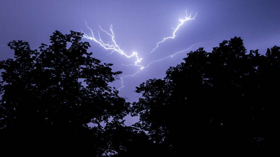 epa09343244 A view of lightning in the sky as a thunder storm hits Berlin, Germany, 14 July 2021. Summer thunderstorms with heavy rain fall hit eastern parts of Germany.  EPA/FILIP SINGER