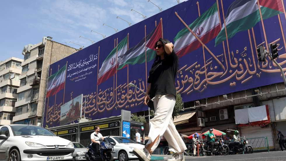 epa13145092 An Iranian woman walks past a billboard displaying the flags of Iran and Palestine on a street in Tehran, Iran, 01 August 2026. Tensions between Iran and the United States over the Strait of Hormuz continue after US President Donald Trump signalled on 31 July 2026 that further US strikes against Iran were possible.  EPA/ABEDIN TAHERKENAREH RESTRICTIONS: NO Access Israel Media/Persian Language TV Stations Outside Iran/Strictly No Access BBC Persian/VOA Persian/Manoto TV/Iran International TV. (As mandated by Iran's Directorate General for Foreign Media) -- RESTRICTIONS: ISRAEL OUT - NO ACCESS ISRAEL MEDIA/PERSIAN LANGUAGE TV STATIONS OUTSIDE IRAN/STRICTLY NO ACCESS BBC PERSIAN/VOA PERSIAN/MANOTO TV/IRAN INTERNATIONAL TV