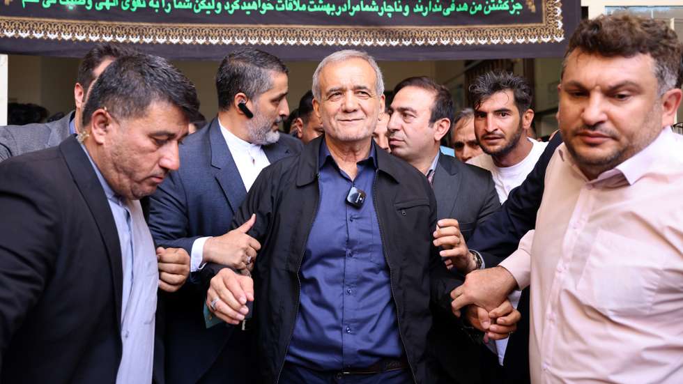 epa11461407 (FILE) - Iranian reformist presidential candidate Masoud Pezeshkian (C) is escorted after casting his vote at a polling station during the presidential election in Ghaleh Hasan Khan, Iran, 05 July 2024 (reissued 06 July 2024). According to a statement issued by the Ministry of Interior, Masoud Pezeshkian won the presidential runoff election, held in the wake of the death of late Iranian President Ebrahim Raisi, whom died in a hellicopter crash. Iran held the second round of its presidential election on 05 July 2024.  EPA/STR