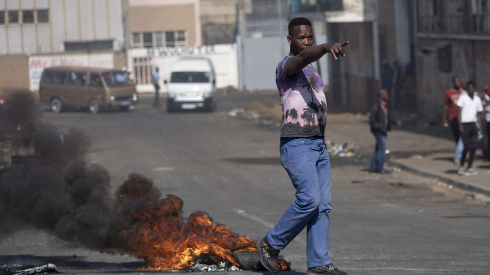 epa09336849 A supporter of ex President Jacob Zuma during ongoing violent clashes in downtown Johannesburg, South Africa, 11 July 2021. President Zuma was arrested on Tuesday 06 July and sentenced to 15 months in prison for contempt of court. Protests by his supporters included shops being looted, car burned and the blocking of city streets.  EPA/KIM LUDBROOK