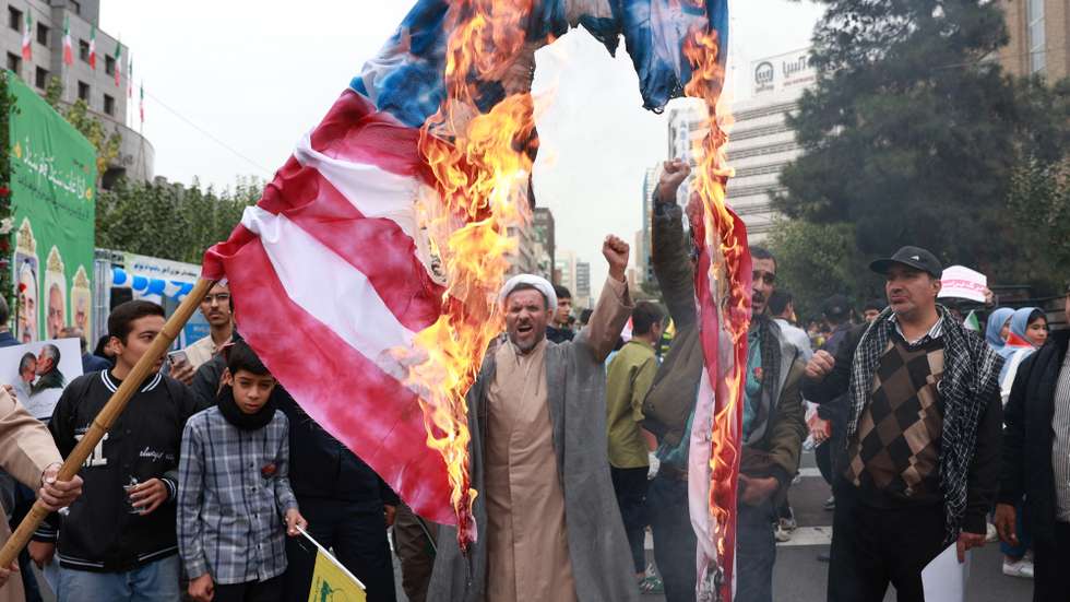 epa11698411 An Iranian cleric chants slogans as Iranians burn a US flag during an anti-US rally marking the 45th anniversary of the US Embassy takeover, in front of the former embassy building in Tehran, Iran, 03 November 2024. Iranian students occupied the embassy on 04 November 1979 after the USA granted permission to the late Iranian Shah to be hospitalized in the United States. Over 50 US diplomats and guards were held hostage by students for 444 days. The Iranian Supreme Leader Ayatollah Ali Khamenei said on 02 November that the US and Israel will definitely receive a harsh response following Israel's strike on Iran in October.  EPA/ABEDIN TAHERKENAREH