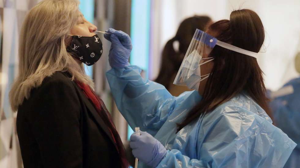 epa08900040 Mildred Barberena (L) of Encino gets swabbed for a Coronavirus test before she can get on a flight to Guatemala in Terminal 2 at Los Angeles International Airport in Los Angeles, California, USA, 22 December 2020.  EPA/ALEX GALLARDO