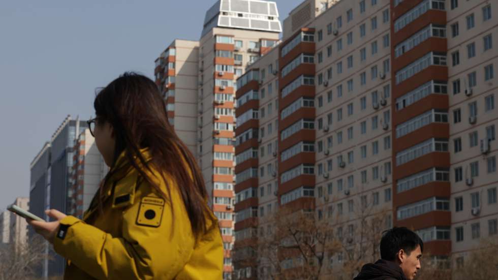 epa12824515 People walk past condominium buildings in Beijing, China, 16 March 2026. According to the National Bureau of Statistics, new home prices in 70 cities fell 3.2 percent year‑on‑year in February 2026, marking the 32nd consecutive month of contraction and the biggest drop since June.  EPA/JESSICA LEE