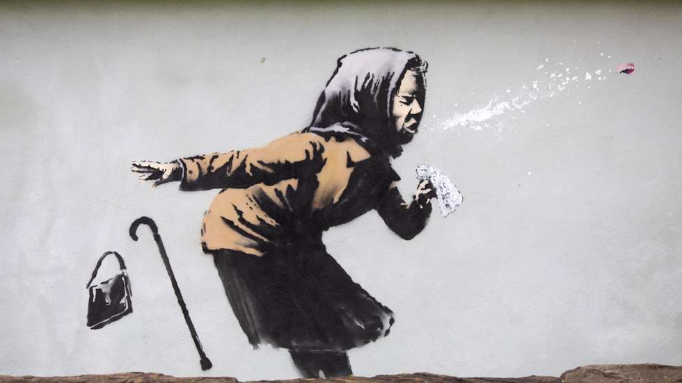 epa08875124 A view of the new creation entitled 'Aachoo!!' by British street artist Banksy that appeared on Vale Street overnight in Bristol, Britain, 10 December 2020. The painting depicts an old woman sneezing with her false teeth flying out.  EPA/JON ROWLEY