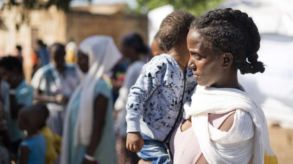 epaselect epa08858036 An Ethiopian refugee woman with her child from Tigray region wait to receive aid at the Um Rakuba refugee camp, the same camp that hosted Ethiopian refugees during the famine in the 1980s, some 80 kilometers from the Ethiopian-Sudan border in Sudan, 01 December 2020 (issued 02 December 2020). According to World Food Programme on 02 December, about 12,000 Ethiopian refugees from Tigray are accomodated in the Um Rakuba camp as over 40,000 Ethiopian refugees fleed to Sudan since the start of fights in the northern Tigray region of Ethiopia. Ethiopia's military intervention   comes after Tigray People's Liberation Front (TPLF) forces allegedly attacked an army base on 03 November 2020 sparking weeks of unrest. According to reports on 02 December 2020, UN reached an agreement with Ethiopian government to provide aid for the Tigray region of Ethiopia.  EPA/ALA KHEIR