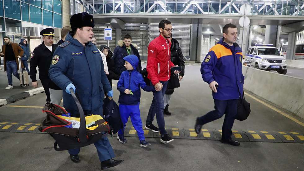 epa10985564 Russian citizens evacuated from the Gaza Strip walk to a bus after their arrival to Domodedovo International Airport in Domodedovo, Moscow region, Russia, early 20 November 2023. A special Russian Emergency Ministry aircraft delivered 117 people who crossed from Gaza through the Rafah checkpoint back to Russia. The evacuation of Russian citizens from the Gaza Strip who found themselves in the zone of the Palestinian-Israeli conflict was organized by the Russian Ministry of Emergency Situations together with diplomats. The first group of 70 citizens crossed the Rafah checkpoint into Egyptian territory on 12 November, with a total of 550 citizens crossing the checkpoint this week. According to Russian Foreign Ministry representative Maria Zakharova, over 1,000 people have signed up for the evacuation lists.  EPA/MAXIM SHIPENKOV
