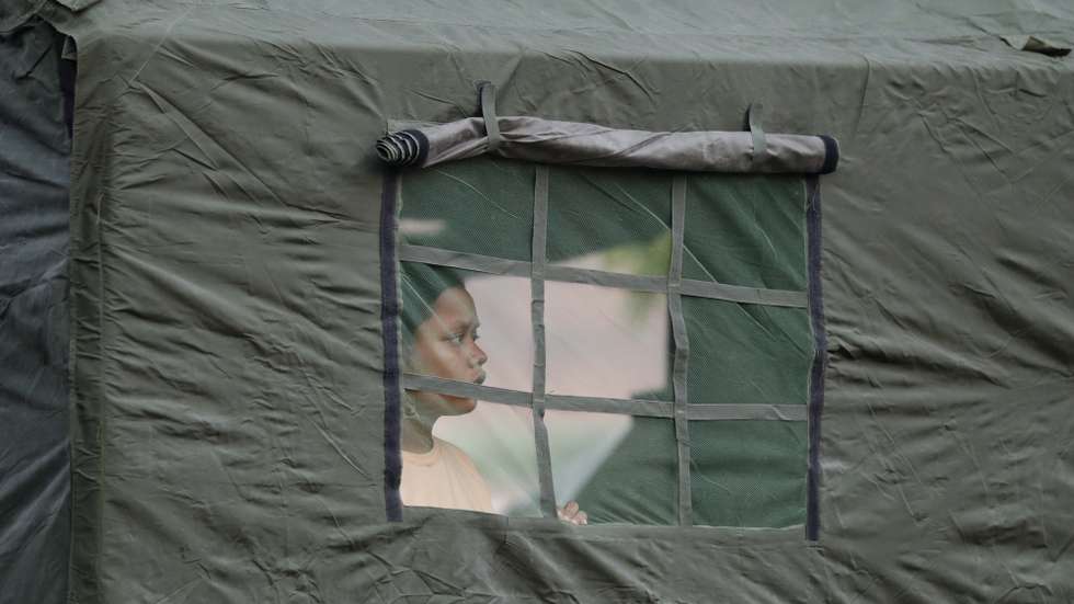 epa12005120 A woman looks from a window of the temporary shelter provided by Myanmar military in Mandalay, Myanmar, 02 April 2025. More than 2,700 people have been killed and thousands injured after a 7.7-magnitude earthquake struck the country on 28 March, according to the Myanmar government.  EPA/NYEIN CHAN NAING