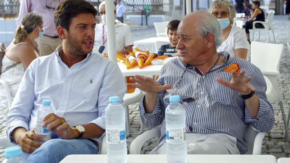 O presidente do PSD, Rui Rio (D), conversa com o presidente do CDS/PP, Francisco Rodrigues dos Santos, enquanto bebem uma água na Praça do Giraldo, momentos antes da inauguração da sede de campanha da coligação PSD/CDS/MPT/PPM à câmara de Évora para as Autarquicas 2021, Évora, 31 de agosto de 2021. NUNO VEIGA/LUSA