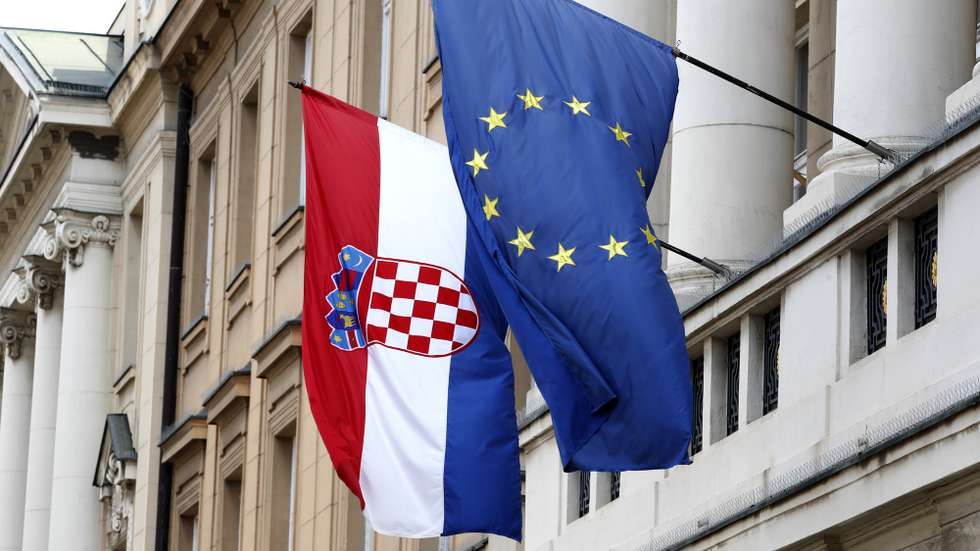epa09960504 The flags of Croatia (L) and European Union (EU) hang from the facade of the Parliament building at old town in Zagreb, Croatia, 20 May 2022. Croatia, which joined the EU in 2013, is set to join the Eurozone in January 2023, with the introduction of the euro as the country's official currency after Croatian lawmakers voted in favor of legislation to bring the shared currency.  EPA/ANTONIO BAT