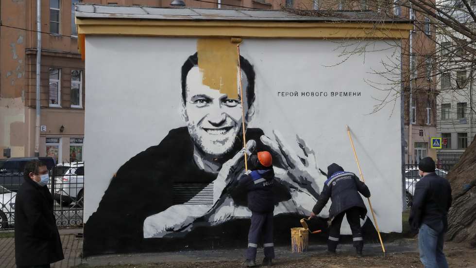 epaselect epa09164791 Municipal workers paint over a graffiti depicting jailed Russian opposition politician Alexei Navalny with wordings reading, 'The hero of the new age', in St. Petersburg, Russia, 28 April 2021. Navalny is currently being held at a prison camp northeast of Moscow, sentenced to imprisonment at the penal camp in early February 2021 for violating parole requirements related to an earlier suspended sentence over 2014 embezzlement charges.  EPA/ANATOLY MALTSEV