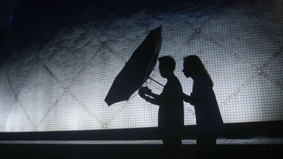 epa12401877 A couple walk along a street after Typhoon Ragasa weakened from T10 to T3, in Hong Kong, China, 24 September 2025.  EPA/MAY JAMES