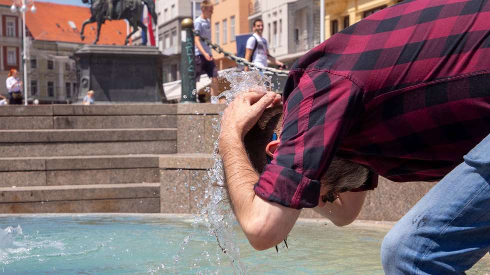 epa10751986 A man refreshes himself at a fountain in Zagreb, Croatia, 17 July 2023. Croatia's Hydrometeorological Service issued a warning on high temperatures of up to 40 degrees Celsius in the following days.  EPA/ANTONIO BAT