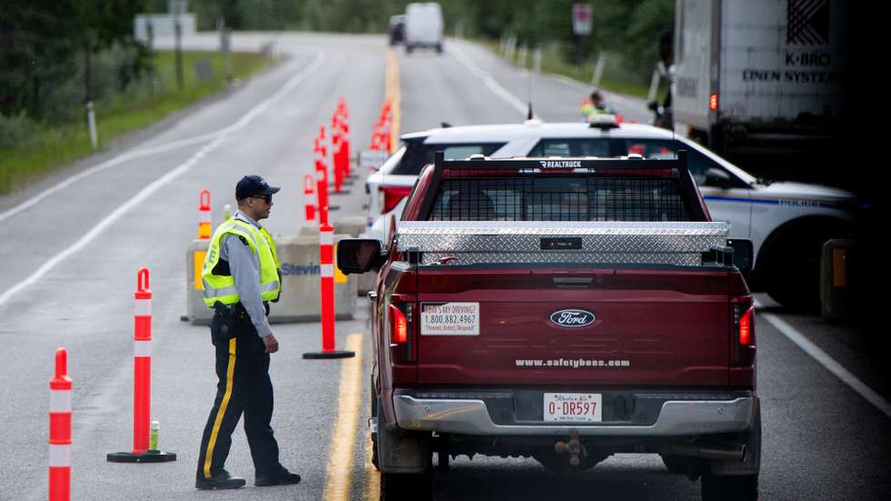 epa12178048 A Royal Canadian Mounted Police (RCMP) officer questions the driver of a vehicle at a checkpoint in Kananaskis, Alberta, Canada, on 15 June 2025, as seen from a media bus. World leaders are expected to gather in Kananaskis, Alberta from June 15 to 17 for the G7 Summit.  EPA/SPENCER COLBY