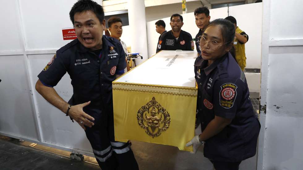epa13110289 Rescue workers carry a coffin of a pub fire victim after relatives identified and claimed the body for funeral rites at the Institute of Forensic Medicine, Police hospital in Bangkok, Thailand, 14 July 2026. At least 30 people were killed and 63 others were injured after a fire engulfed the Rong Beer Na Lat Phrao pub, according to the Bangkok Metropolitan Administration.  EPA/RUNGROJ YONGRIT