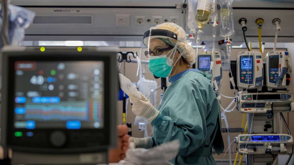 epa08841109 A health worker assists a patient in the intensive care unit at the Hospital Vall d&#039;Hebron in Barcelona, Spain, 25 November 2020. The situation in Catalan hospitals continues getting better with a decrease of covid-19 cases under 2,000 patients and 500 seriously ill. In the last 24 hours more than 1,700 new cases have been reported with 30 new dead people.  EPA/ALBERTO ESTEVEZ