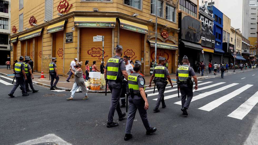 epa08904934 Members of Brazilian police patrol in front of closed stores due to the coronavirus pandemic at 25 de Marzo street, the major commerce centre in Sao Paulo, Brazil, 26 December 2020.  EPA/Sebastiao Moreira