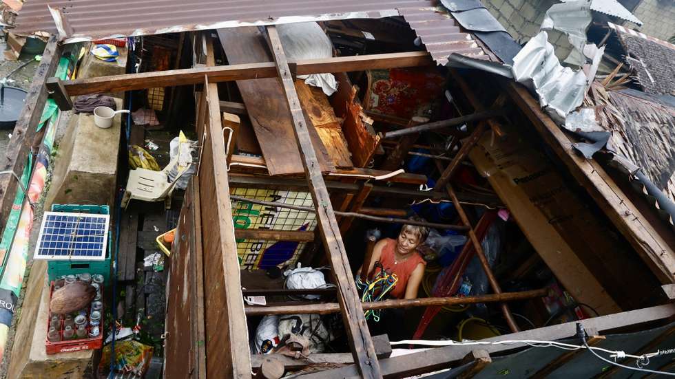 epaselect epa11726685 An elderly villager woman collects belongings inside a damaged home in the typhoon-hit municipality of Baler, Aurora province, Philippines, 18 November 2024. Local government units in  typhoon Man-yi’s path from Bicol region to Luzon region conducted pre-emptive evacuation of citizens to safeguard against floods and strong winds.  EPA/FRANCIS R. MALASIG