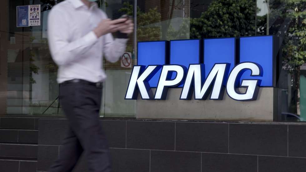 epa08777182 A man walks past the logo of auditing firm KPMG in the financial district in Singapore, 27 October 2020. The fallout of the global Covid-19 coronavirus pandemic has had a range of effects across workers from different sectors of the economy. As businesses gradually open up, economists are describing a 'K-shaped' recovery caused by lower wage workers affected by health and safety regulations, while white collar workers remain largely unaffected due to the advent of telecommuting and work from home arrangements.  EPA/WALLACE WOON