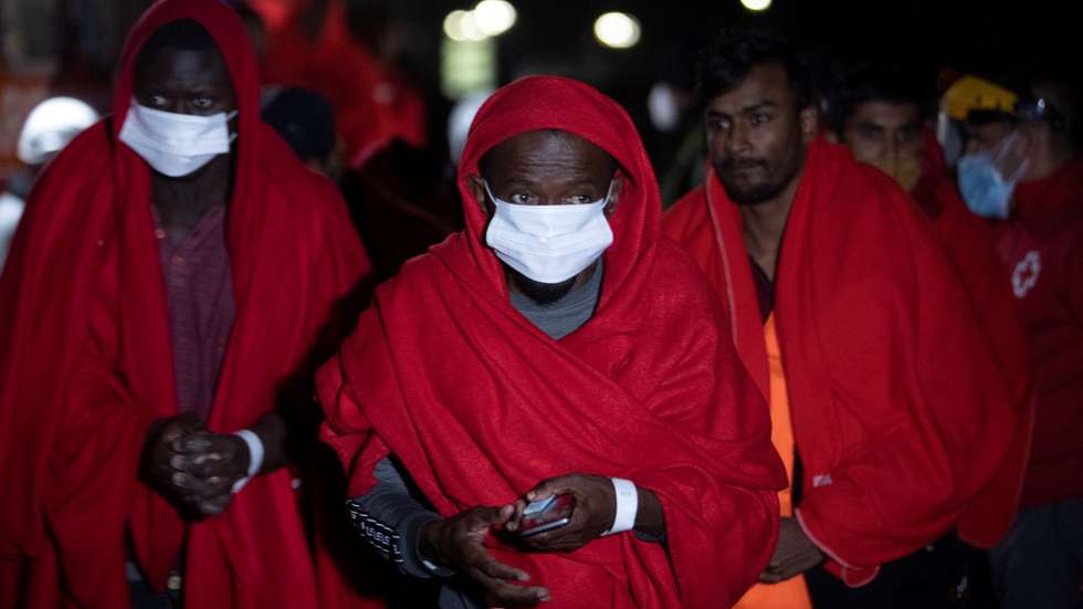 epa08883017 Several Asian and sub-Saharan migrants arrive at the port after they were rescued by a Spanish Sea Rescue ship off Spanish mainland coast in Motril, southern Spain, early 14 December 2020. A boat with 48 migrants, including 11 from Asian countries, on board, was rescued by Spanish authorities after a cargo ship found them 53 miles off Spanish coast.  EPA/MIGUEL PAQUET