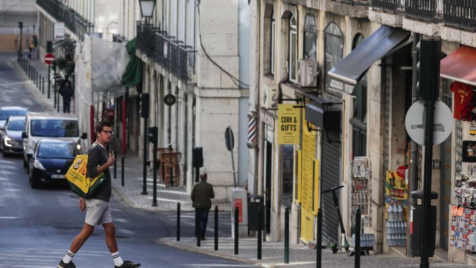 Um turista atravessa a rua da Madalena na zona da baixa pombalina de Lisboa, 20 de novembro de 2020. A falta de turismo na cidade de Lisboa devido à pandemia de Covid 19 levou a que muitos estabelecimentos comerciais, alguns deles emblemáticos e de familias há gerações estejam em risco de fechar. (ACOMPANHA TEXTO DA LUSA DE 22 DE NOVEMBRO DE 2020) TIAGO PETINGA/LUSA